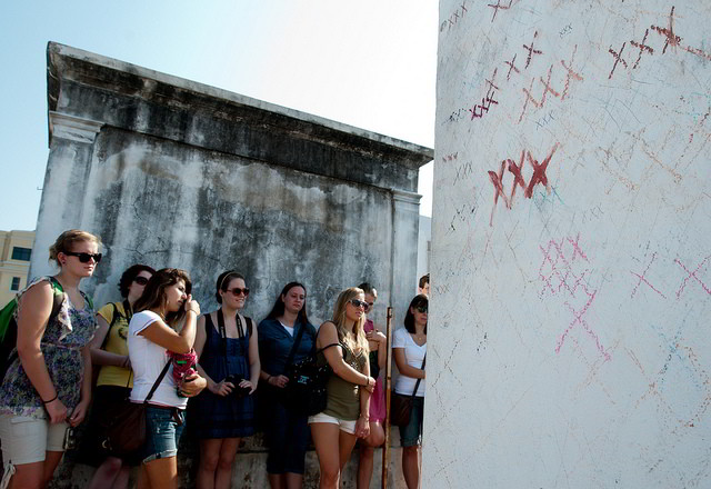 Students visit the grave of voodoo queen Marie Laveau in St. Louis Cemetery #1. (Photo via Tulane Public Relations on Flickr)