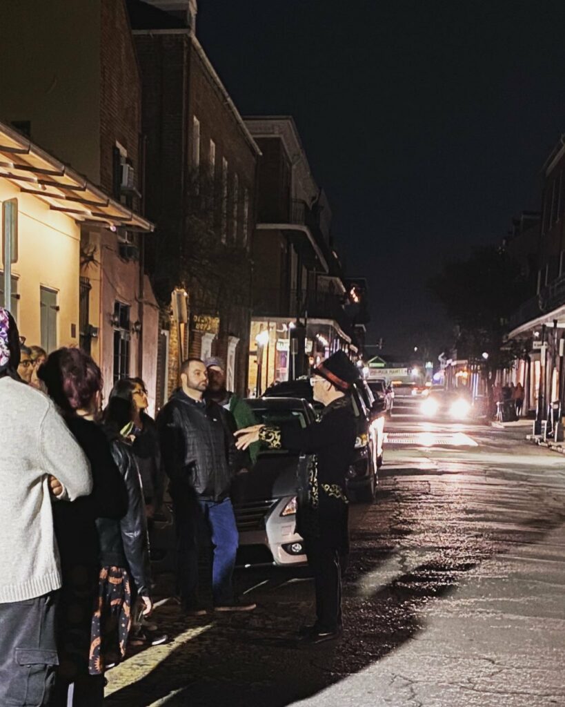 A tour guide taking NOLA visitors on a haunted walking tour of New Orleans, exploring the spooky history of the French Quarter.