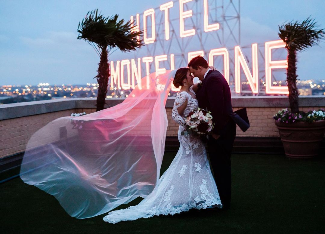 Photo of couple at dusk with Hotel Monteleone's rooftop marquee in the background.