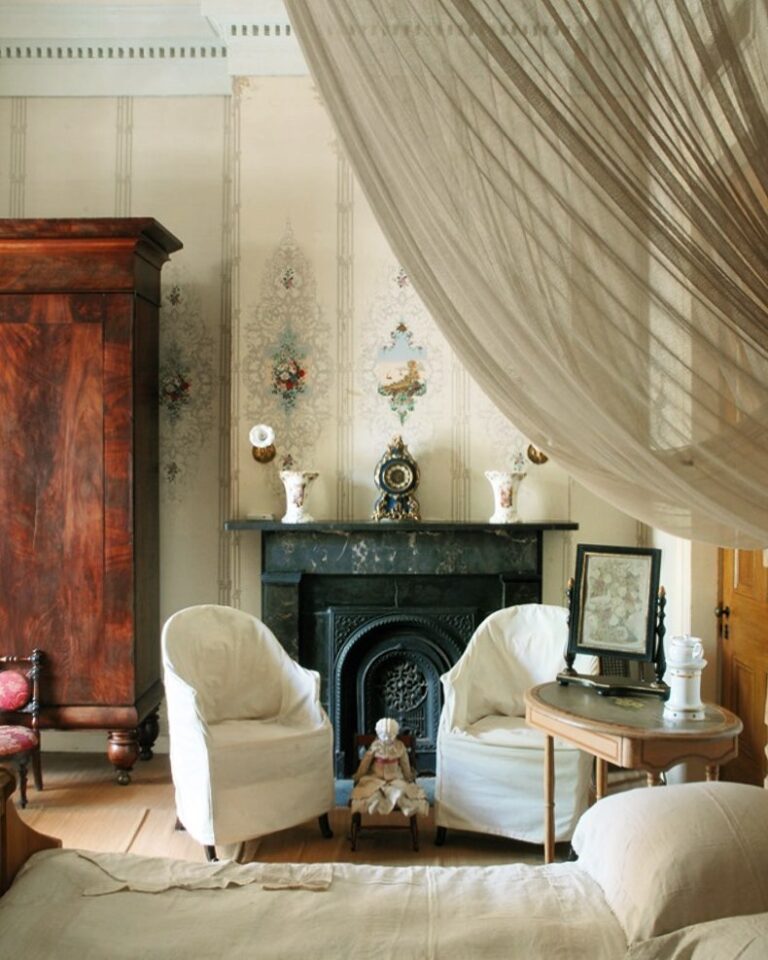 Living space in the Hermann-Grima House furnished with 19th century chairs, bed, and wardrobe.