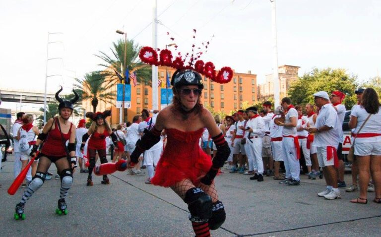 NOLA Bulls roller derby member skates through New Orleans dressed up for the Running of the Bulls event as revelers in dressed in white gather