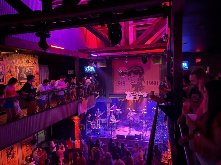Tipitina's music venue with concert goers watching a band no stage from the balcony and floor