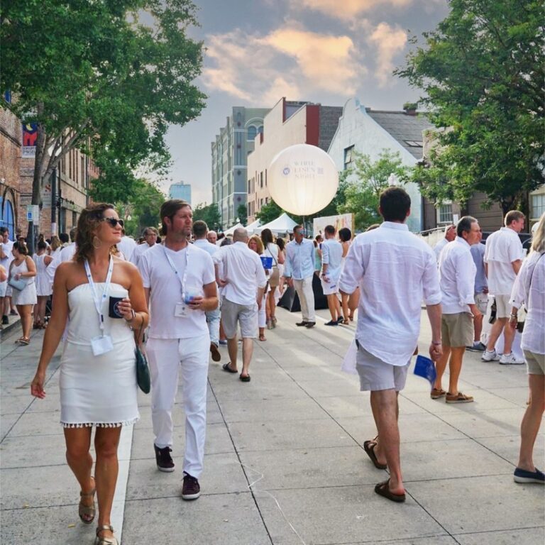 Folks dressed all in white stroll Julia Street's art galleries celebrating White Linen Night in New Orleans